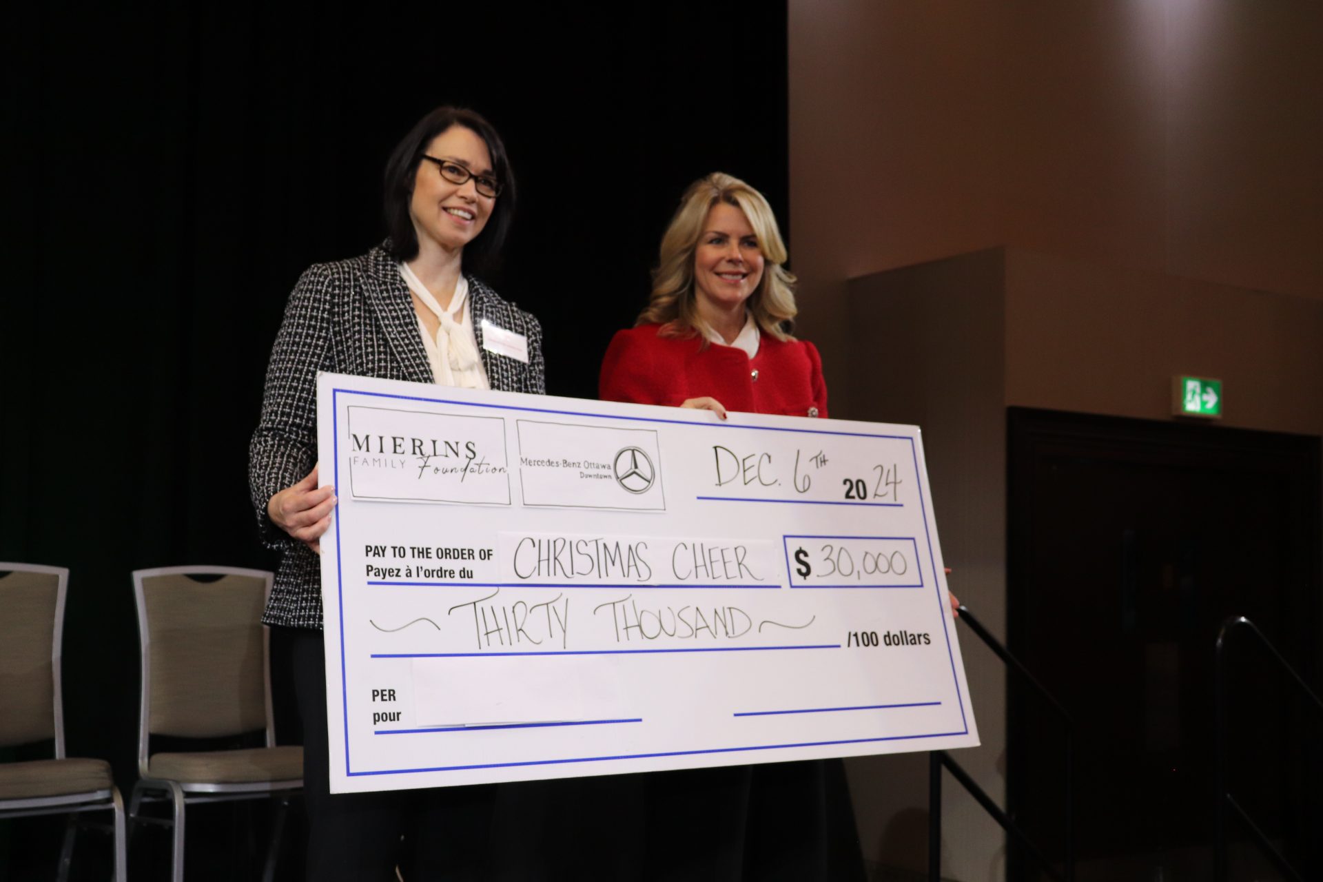 Lisa Mierins (right) of presenting sponsor the Mierins Foundation presents a cheque to Samantha Hamilton for the Christmas Cheer fundraiser. (Photo by Mia Jensen)